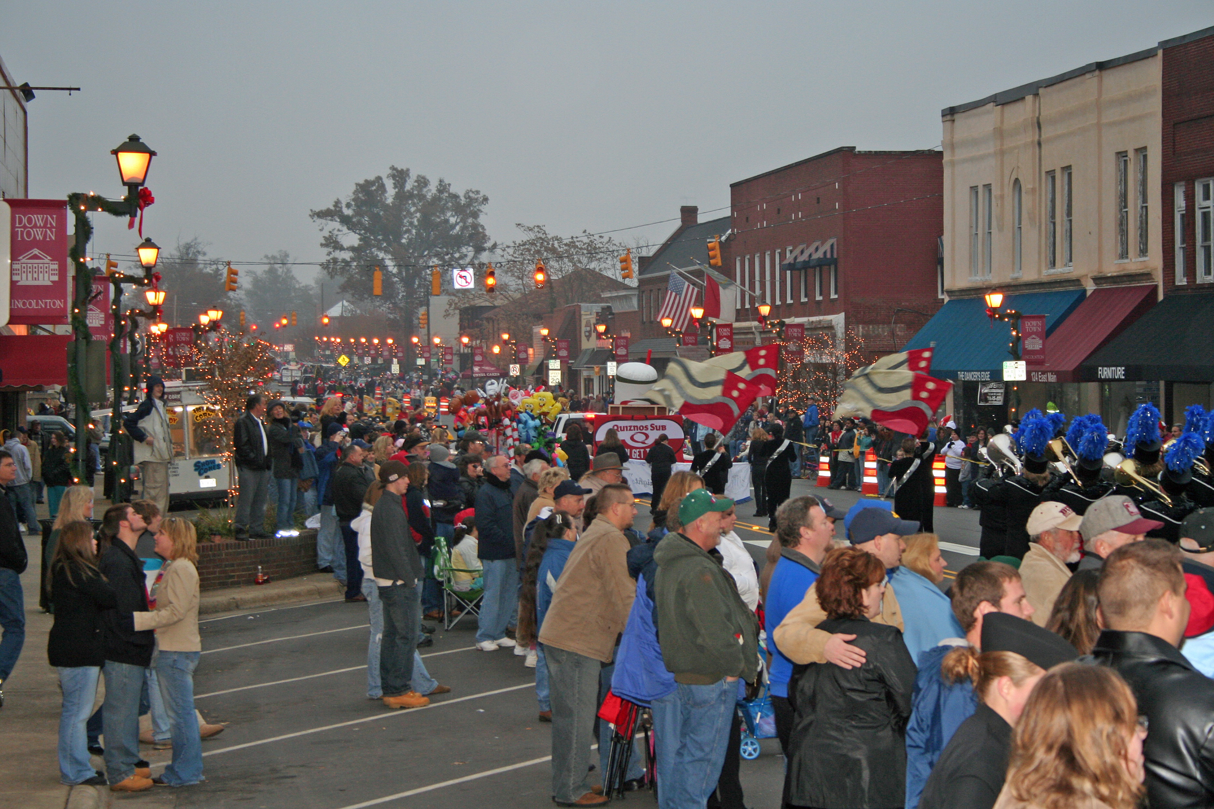 People gather for a parade on a foggy day